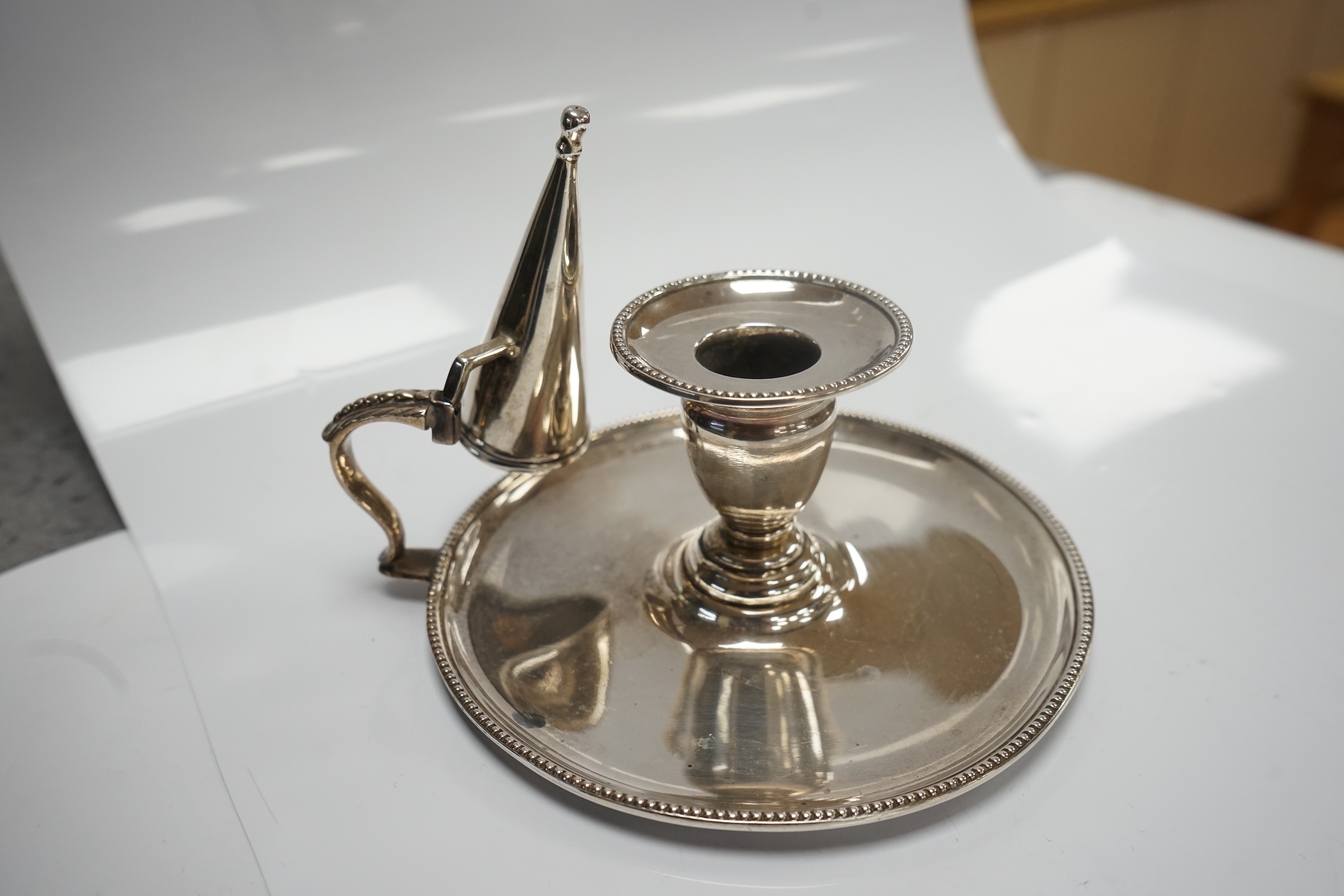 A Victorian silver chamberstick, Walker Knowles & Co, Sheffield, 1859, with later associated silver extinguisher, diameter 13.2cm. Condition - fair